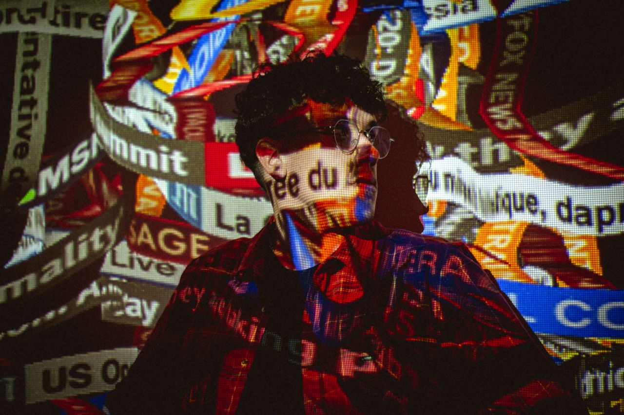 Home Conceptual photo of a person with news ticker projections on their face and body.
